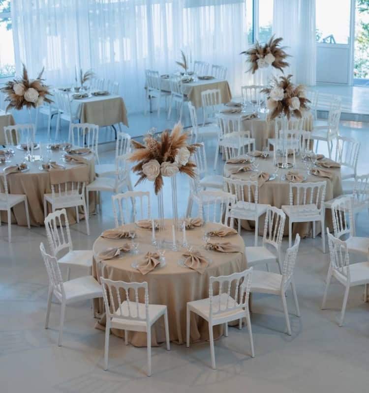 Ein Raum mit Tischen und Stühlen für eine Hochzeitsfeier.