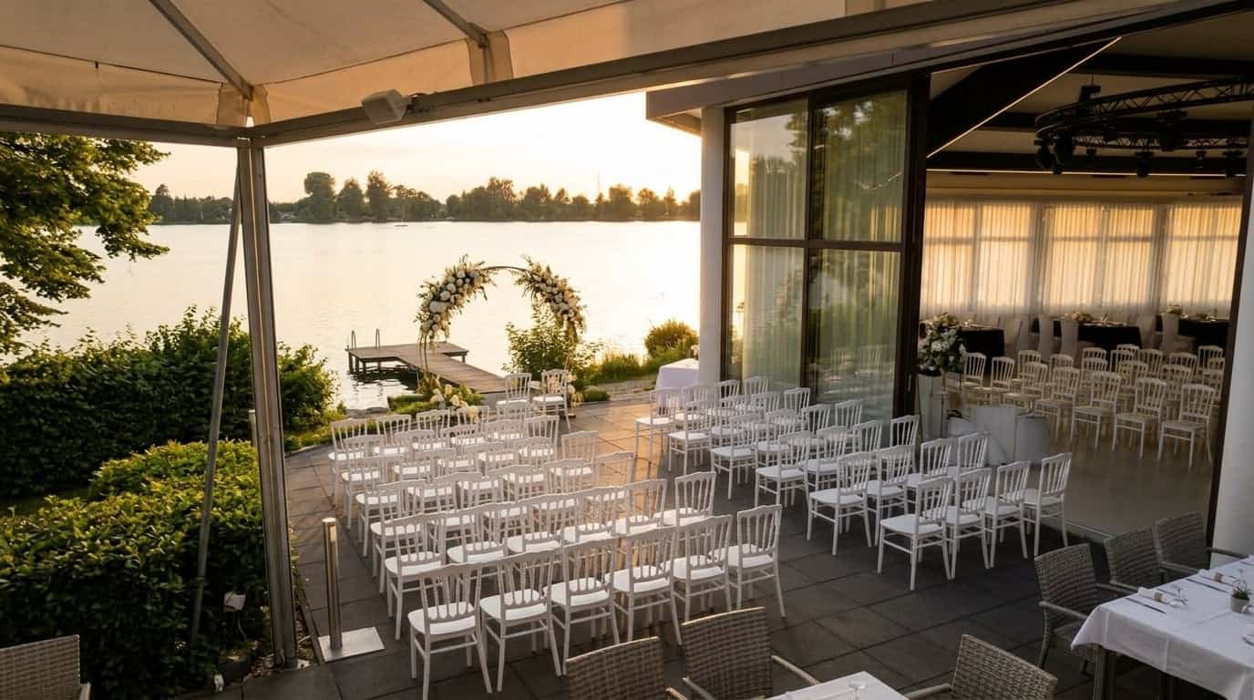 Elegante Outdoor-Hochzeitszeremonie auf der Seeterrasse bei Sonnenuntergang