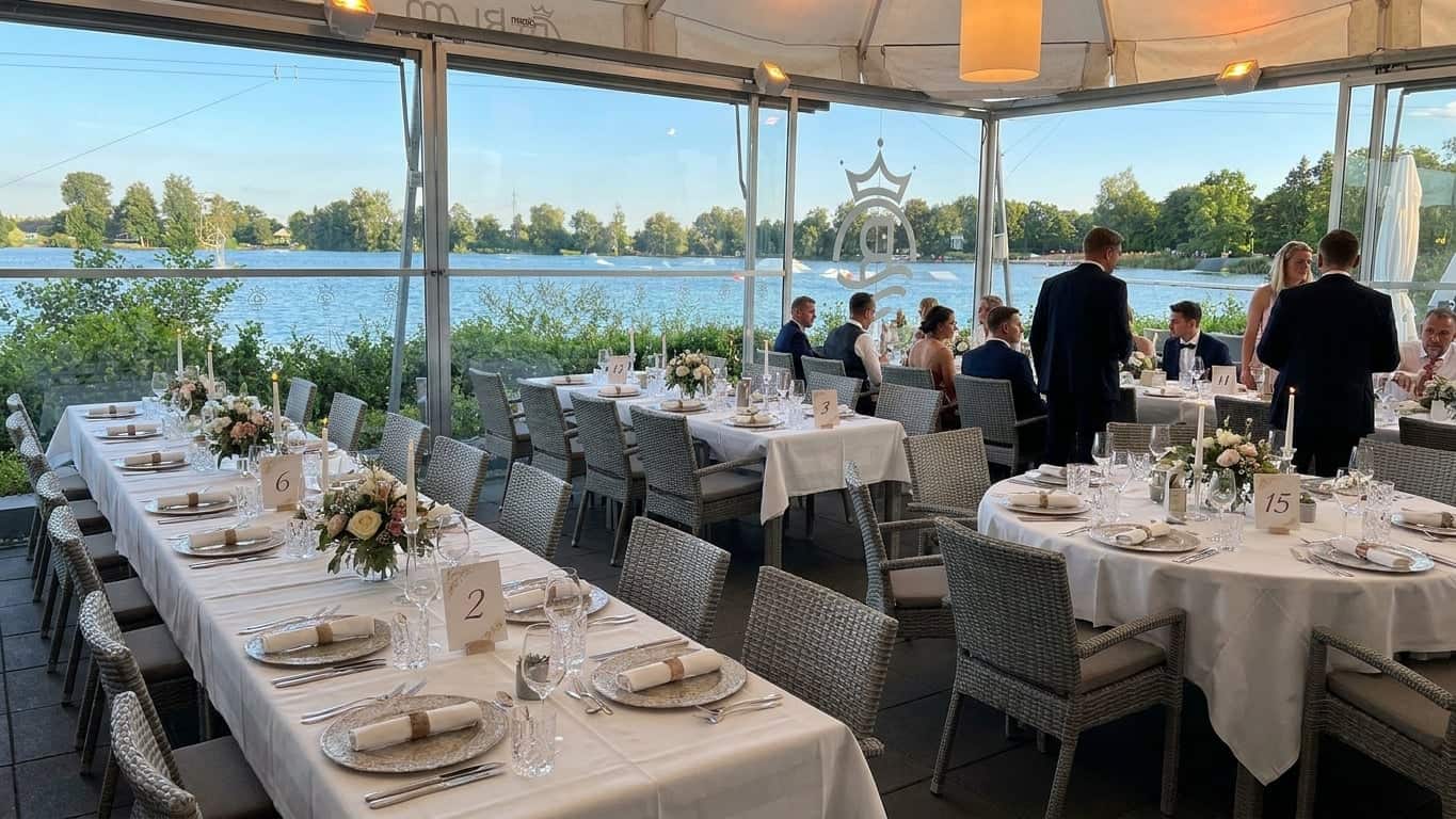 Elegante Eventlocation am See mit runden Tischen für das Abendessen