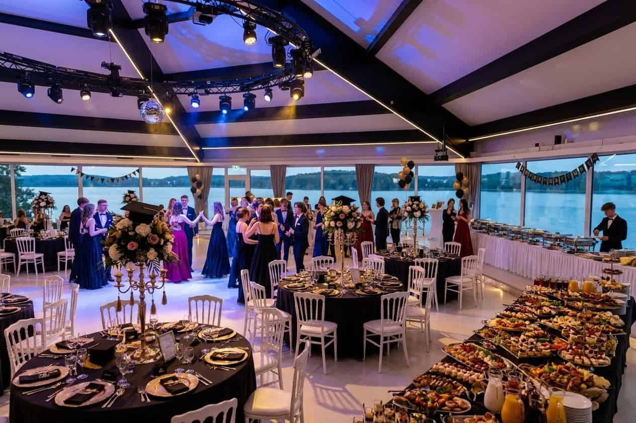 Elegantes Buffet mit internationaler Küche auf dekoriertem Tisch mit Seeblick