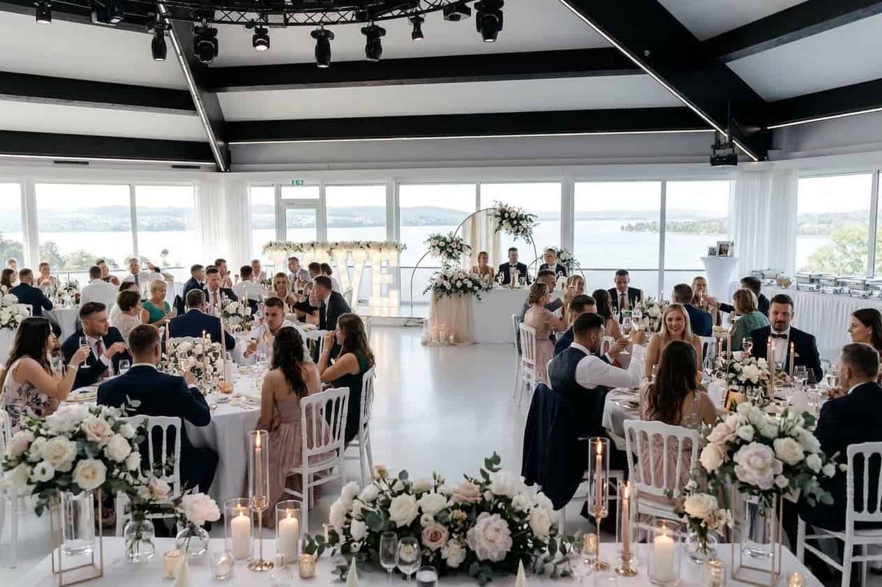 Romantische Sommerhochzeits-Tischdekoration mit Blumen und Seeblick